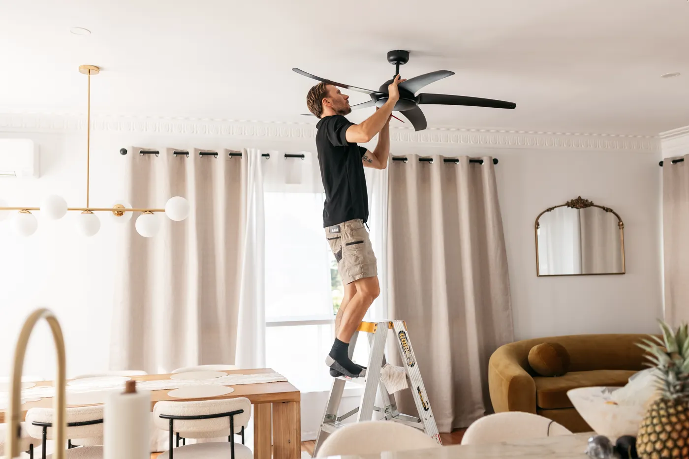 Moritz Electrical installing a remote-controlled ceiling fan in a living room