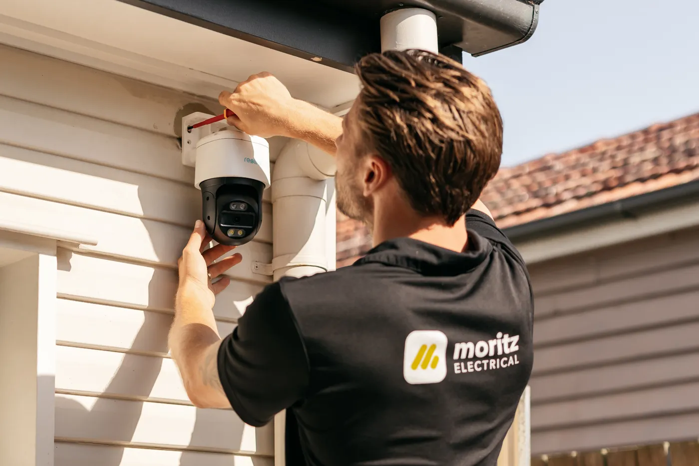 Moritz Electrical installing a home security camera under the eaves of a Brisbane home